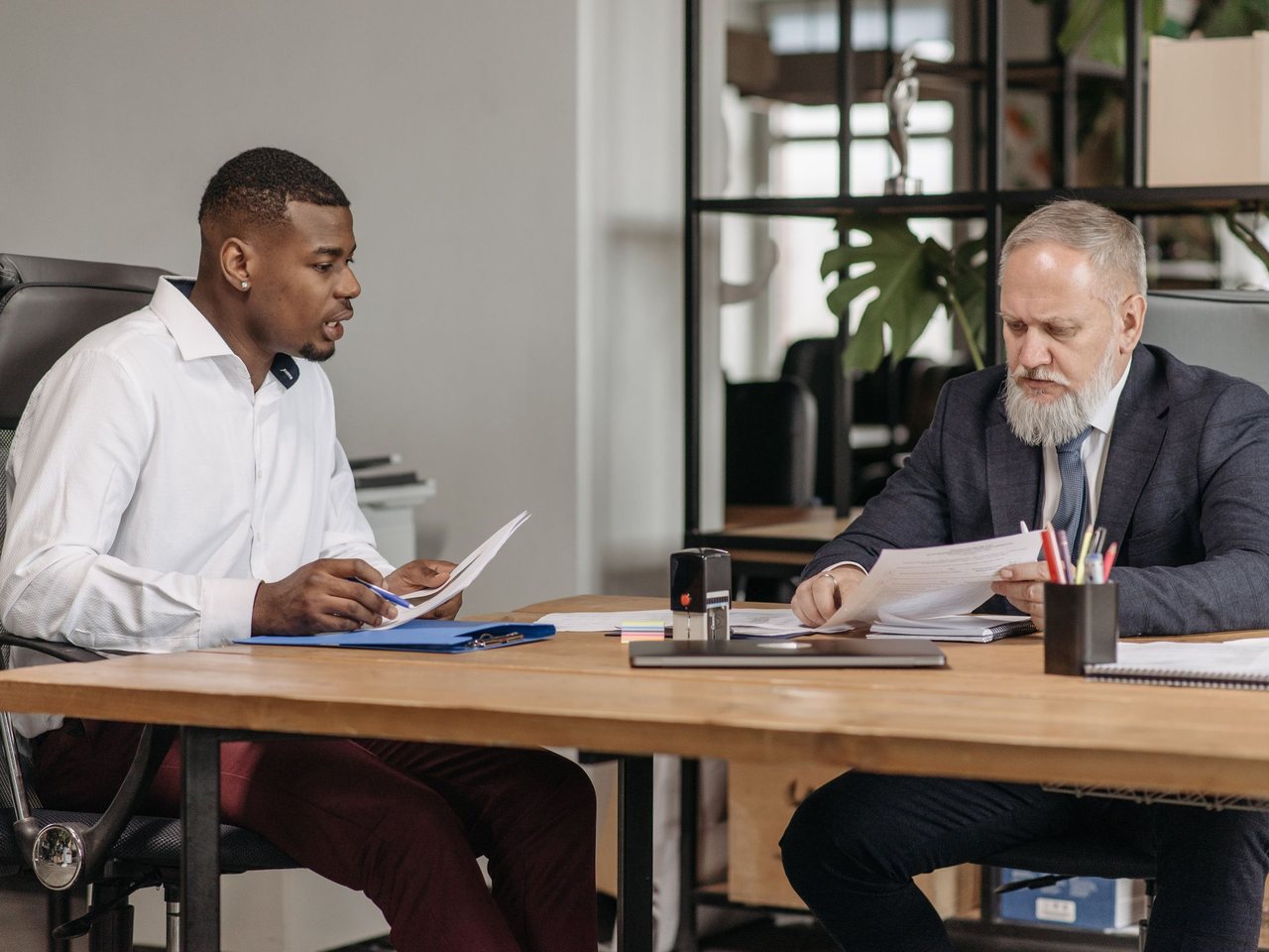 Two professionals reviewing documents together at an office desk